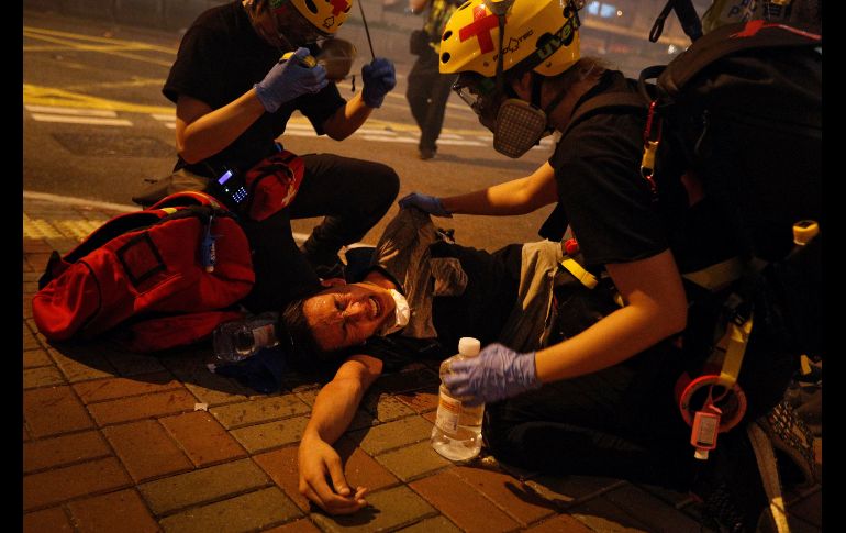 Personal médico auxilia a un manifestante afectado por el gas lacrimógeno. AP/B. Yip