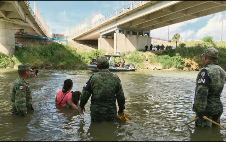 Elementos de la Guardia Nacional aconsejan a una familia de guatemaltecos que no cruce el Río Bravo. EFE