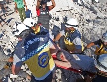 Miembros de los Cascos Blancos extraen a una persona herida de entre los escombros de un edificio derrumbado. AFP/A. Ketaz