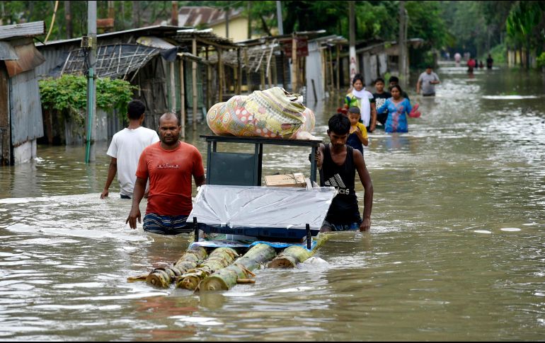 Habitantes trasladan pertenencias tras el desbordamiento de un río en Pathsala, Assam. Las inundaciones han afectado a 20 de 33 estados. AFP/D. Talukdar