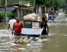 Habitantes trasladan pertenencias tras el desbordamiento de un río en Pathsala, Assam. Las inundaciones han afectado a 20 de 33 estados. AFP/D. Talukdar