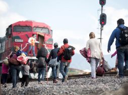 Familias de migrantes centroamericanos intentan subirse al tren 
