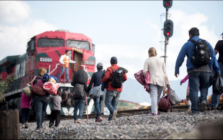 Familias de migrantes centroamericanos intentan subirse al tren 