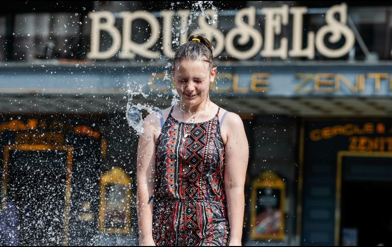 Una joven se mete este viernes a una fuente en Bruselas, la capital belga. El país padece la ola de calor que afecta a Europa. EFE/EPA/. Lecocq