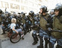 Un persona en silla de ruedas se abre paso entre la ola de antimotines, en la capital rusa. EFE