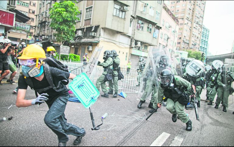 Manifestantes huyen de los granaderos en el Distrito Yuen Long. AP