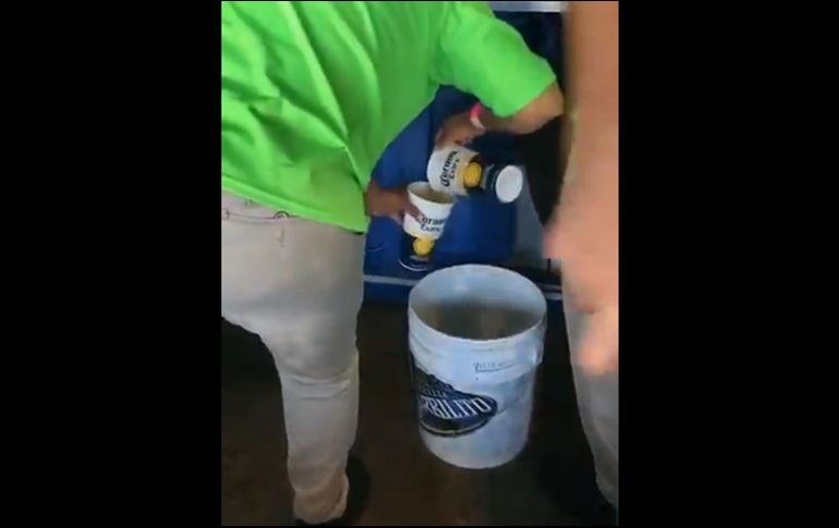 En la imagen se aprecia a una vendedora reciclando la bebida alcohólica en una cubeta para presuntamente ser revendida. TWITTER
