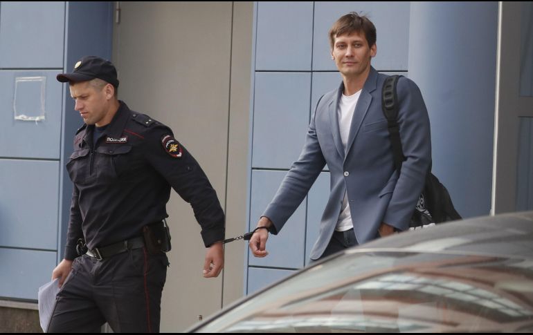 Un policía escolta al exdiputado Dmitry Gudkov antes de una audiencia por la participación en una protesta no autorizada. EFE/S. Ilnitsky