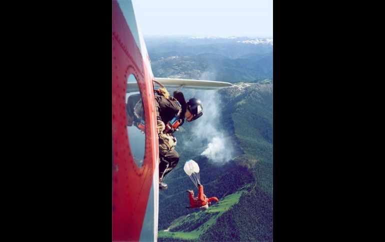 Elementos que participan en el combate al fuego saltan con paracaídas en Taiga.