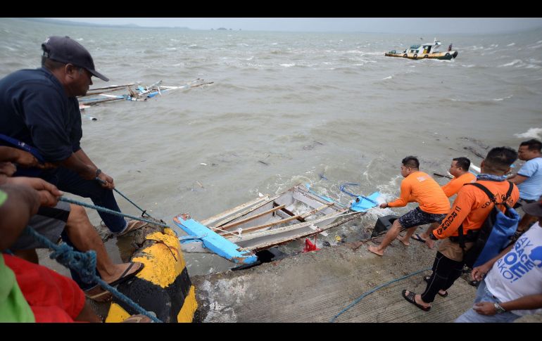 Guardacostas filipinos sacan hoy del agua los restos de uno de los bote que naufragó cerca de la costa de la isla Guimaras, en la region de Bisayas. EFE/L.Solinap