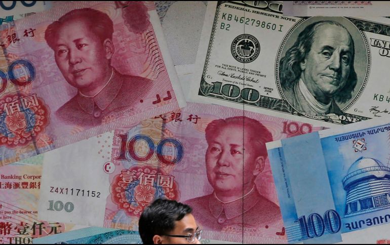 El yuan cayó a poco más de siete por dólar el lunes, lo que ocasionó el desplome de las principales bolsas de valores. AP/K. Cheung