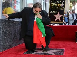 Del Toro besa una bandera de México al recibir su estrella. AP/W. Sanjuan