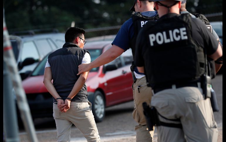 Policías llevan a un hombre detenido en Morton. AP/R. Solis