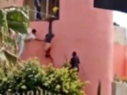 Los bomberos lograron atarlo de una pierna para evitar que cayera y procedieron a entregarlo a la Policía; no obstante, uno de los oficiales tomó un palo de escoba y le comenzó a pegar mientras pendía de la soga. ESPECIAL