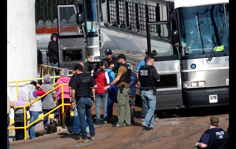 Trabajadoras detenidas en una planta en Morton se dirigen a un autobús para su traslado. AP/R. Solis
