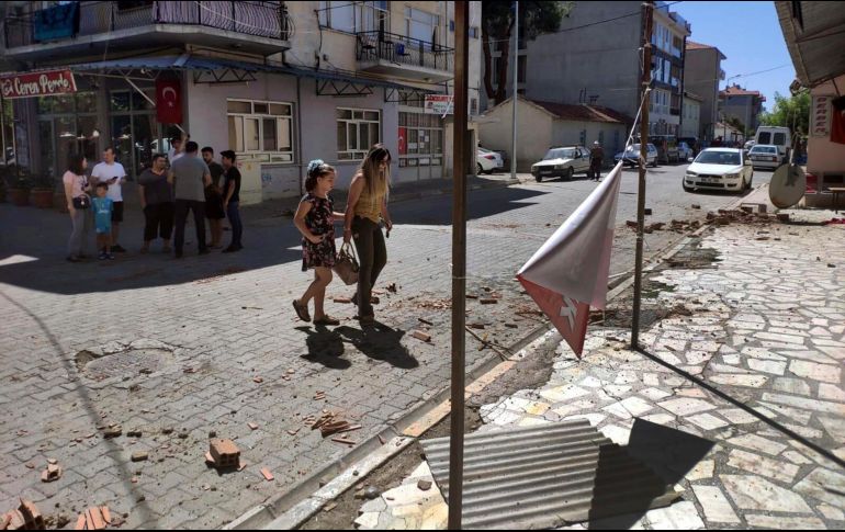 Daños menores se aprecian en las calles mientras los residentes permanecen afuera de los edificios en la provincia de Denizli, al oeste de Turquía. AP/R. Cetin