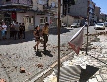 Daños menores se aprecian en las calles mientras los residentes permanecen afuera de los edificios en la provincia de Denizli, al oeste de Turquía. AP/R. Cetin