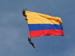 Los suboficiales pendían de una cuerda y sostenían una bandera de Colombia. AFP/J. Sarmiento
