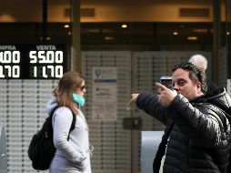 Un hombre se fotografía delante de una casa de cambio donde se anuncia el elevado precio del dólar. AP/N. Pisarenko