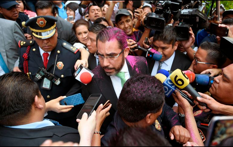Jesús Orta habla con los medios luego de que un grupo de manifestantes le arrojara diamantina morada. AFP/A. Estrella