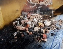 A la llegada de los Bomberos de Guadalajara, los vecinos ya habían rescatado al menor, realizando varios boquetes en la pared de la habitación donde se hallaba. ESPECIAL/ Bomberos de Guadalajara