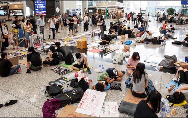 Un grupo de manifestantes permanece en el aeropuerto de Hong Kong en un área designada para la sentada, sin bloquear el paso de viajeros. EFE/EPA/M. Candela