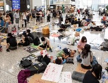 Un grupo de manifestantes permanece en el aeropuerto de Hong Kong en un área designada para la sentada, sin bloquear el paso de viajeros. EFE/EPA/M. Candela