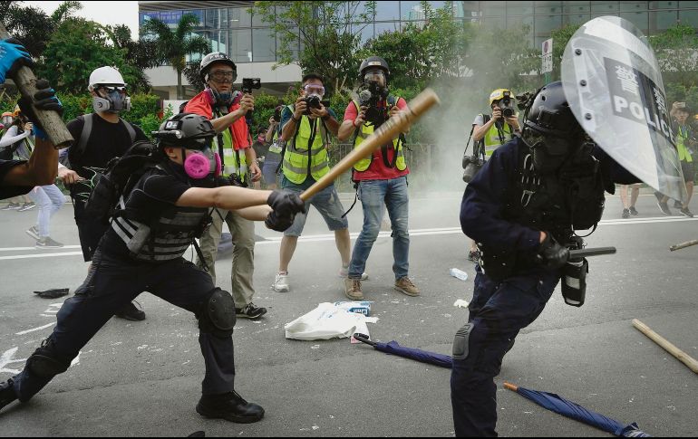 Un inconforme mide fuerzas con un oficial durante las manifestaciones de hongkoneses. AP