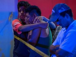 Familiares de las víctimas aguardan al exterior del local donde se reportaron 23 muertos y 13 heridos de gravedad. EFE / A. Hernández