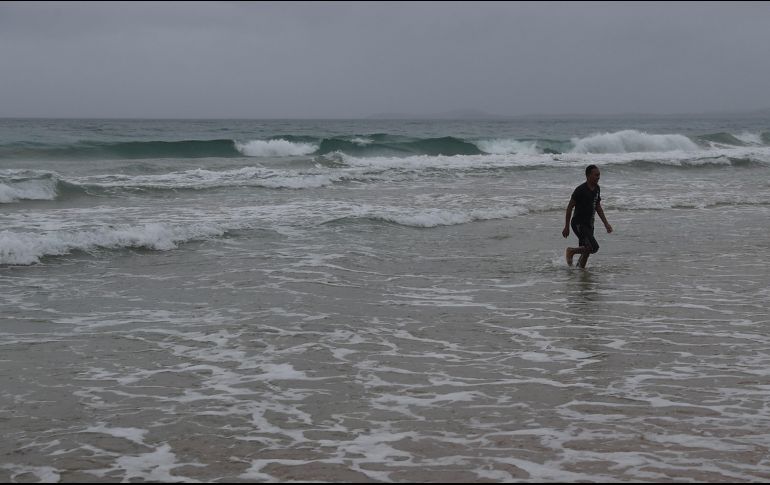 Una persona camina en la playa de Luquillo, en Puerto Rico, previo a la llegada de 