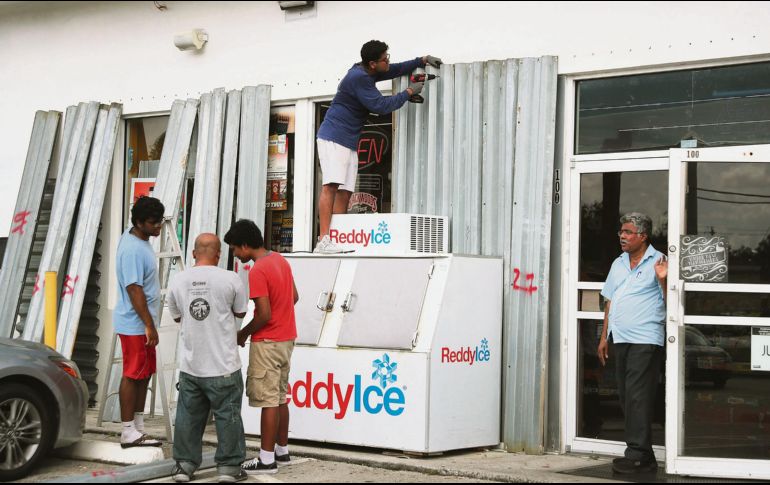 Residentes de Florida protegen sus negocios a la espera de que el fenómeno toque tierra. AFP