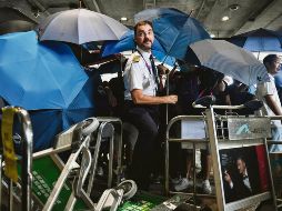 Se cubrieron con paraguas para evitar ser reconocidos. AFP