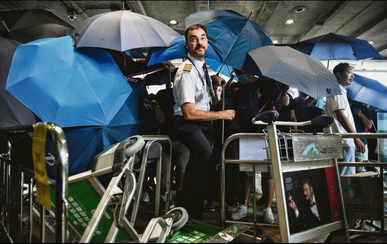 Se cubrieron con paraguas para evitar ser reconocidos. AFP