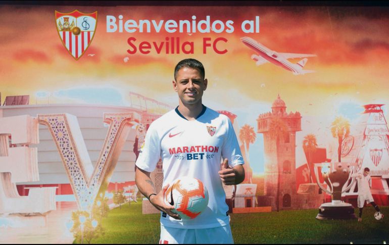 El delantero tapatío vistió los colores del Sevilla durante su presentación oficial. AFP