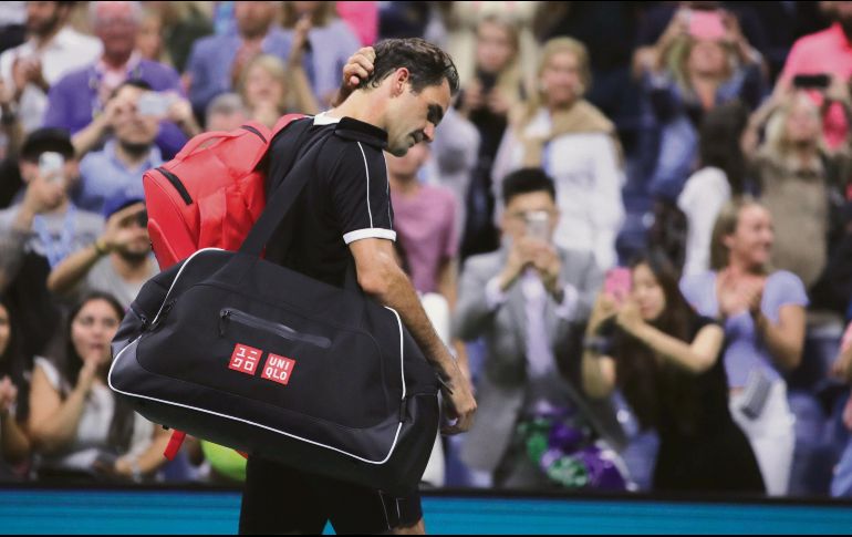 Roger Federer se retira cabizbajo de la cancha tras caer ayer en cinco sets ante Grigor Dimitrov. AP