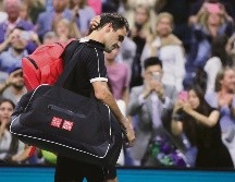 Roger Federer se retira cabizbajo de la cancha tras caer ayer en cinco sets ante Grigor Dimitrov. AP