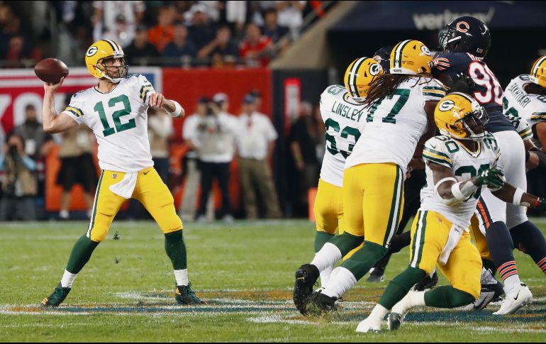 Aunque no brilló como en otras noches, Aaron Rodgers encabezó a la ofensiva de los Packers para comenzar la temporada con el pie derecho ante sus eternos rivales. AP
