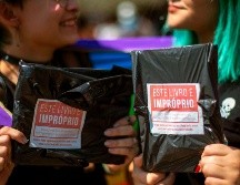 Mujeres muestran dos de los 14 mil libros de temas LGBT comprados y regalados en la bienal de Río de Janeiro por el youtuber Felipe Neto, en protesta contra la censura del alcalde.  AFP/Bienal do Livro do Rio