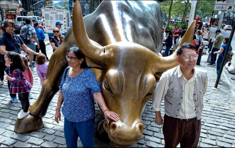 Personas posan junto al toro este domingo en Nueva York. AP/C. Ruttle