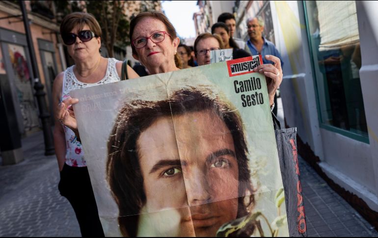 Una mujer sostiene una foto del fallecido cantante y compositor español, Camilo Sesto, mientras hace cola para ver su ataúd en Madrid.  AP / B. Armangue
