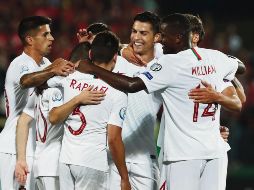 El astro de Portugal, Cristiano Ronaldo, es felicitado por sus compañeros tras anotar uno de sus cuatro goles ayer ante Lituania. AP