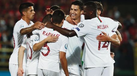 El astro de Portugal, Cristiano Ronaldo, es felicitado por sus compañeros tras anotar uno de sus cuatro goles ayer ante Lituania. AP