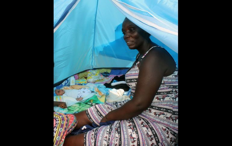 La migrantes y su bebé permanecen en un campamento que han montado sus padres afuera de la estación migratoria en Tapachula. EFE/J. Blanco