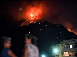 El incendio comenzó la víspera en las montañas que rodean la estación balnearia de Lutraki. EFE / V. Psomas