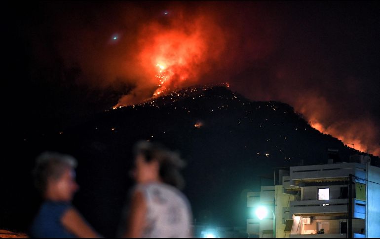 El incendio comenzó la víspera en las montañas que rodean la estación balnearia de Lutraki. EFE / V. Psomas