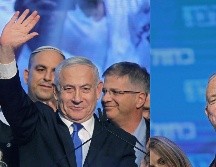 Benjamin Netanyahu (i) saluda hoy a sus seguidos en la sede de su partido Likud en Tel Aviv, mientras Benny Gantz (d) hace lo propio en la sede del Azul-Blanco. AFP/M. Kahana y E. Dunand