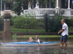 Un hombre traslada a dos niñas a un refugio a bordo de una pequeña lancha. AP/K. Walling-The Galveston County Daily News