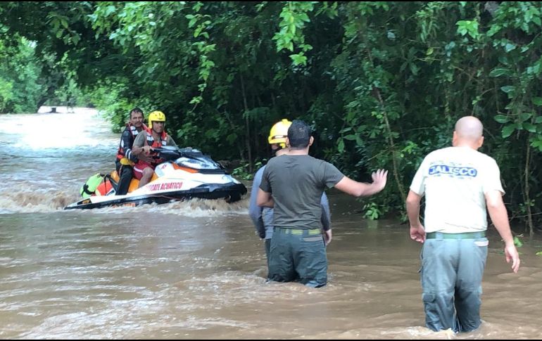 Personal de Protección Civil del Estado trabajan en el rescate de varias personas que quedaron atrapadas en la comunidad de Chamela por los altos niveles del agua. ESPECIAL / Protección Civil de Jalisco