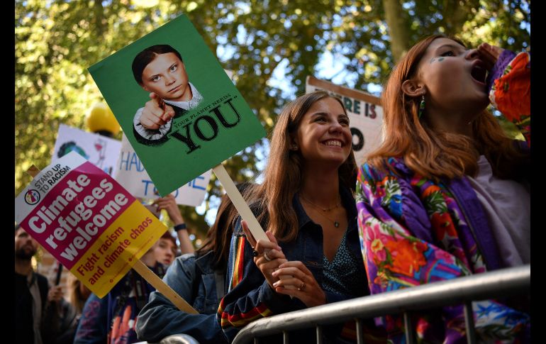 Una joven se manifiesta en Londres, Inglaterra, con una imagen de Greta Thunberg.