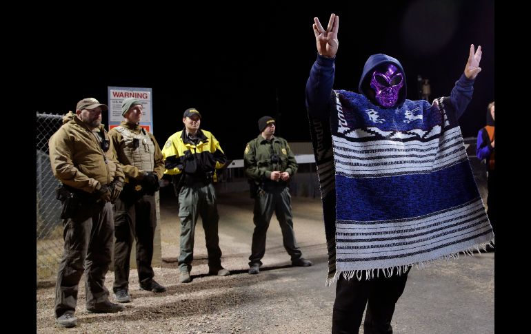 Un hombre con máscara de extraterrestre se ve mientras policías resguardan la entrada de la base militar cerca de Rachel, en Nevada.AP/J. Locher